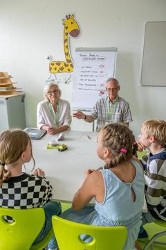 Ältere Menschen mit Kindern am Tisch