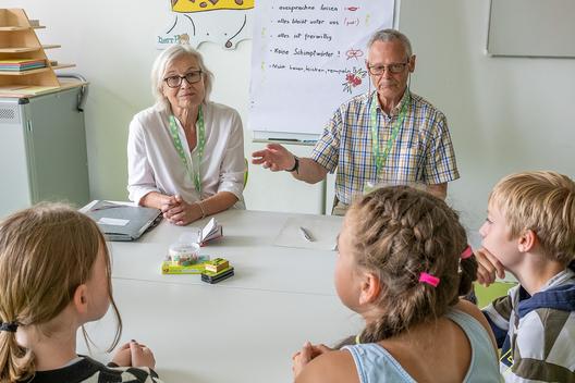 Ältere Menschen mit Kindern am Tisch