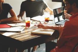 Menschen am Tisch bei Besprechung