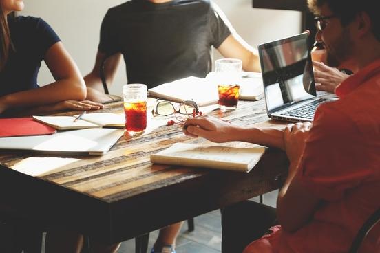 Menschen am Tisch bei Besprechung